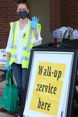 Librarian waves for curbside book pick-up