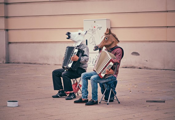 two people in horse masks playing accordians
