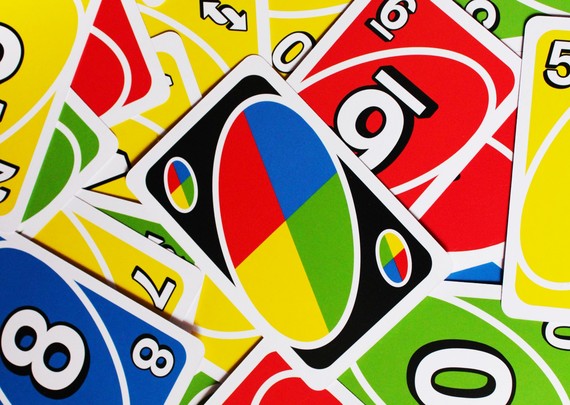 Uno cards scattered on the table with a wild card in the middle.