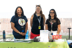 3 EPL staff standing outside at table