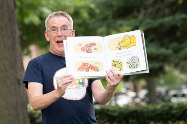 Children's librarian Brian Wilson showing pictures in a book