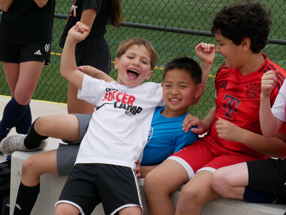 boys sitting next to each other in soccer uniforms