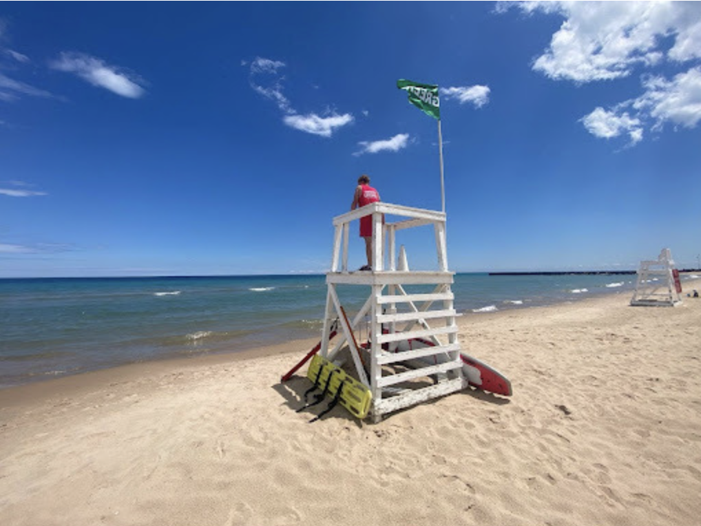 Lifeguard in chair looking at lake 