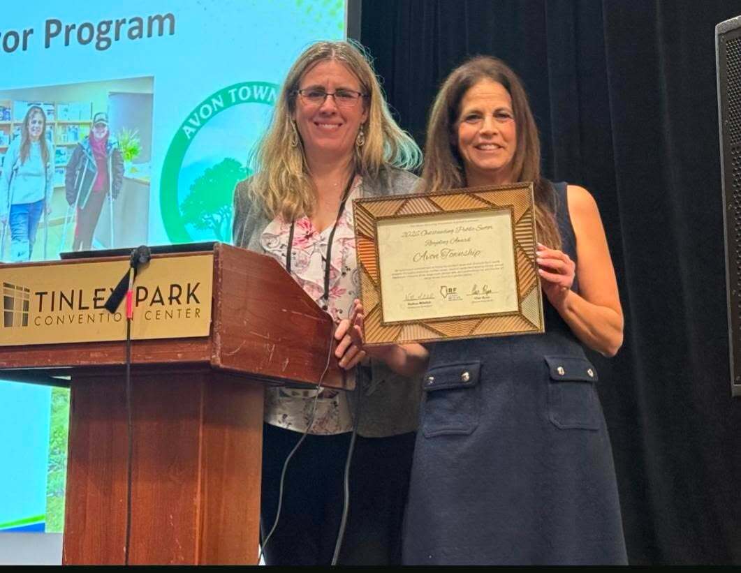 Avon Township Supervisor Michele Bauman holding award