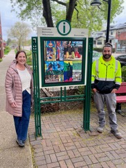Mimi Comerford, Vice President of the Oak Park Arts District and Streets Division Equipment Operator Taras Horalewskyj alongside a refurbished sign