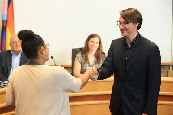 Village Clerk Christina Waters and Trustee Derek Eder shake hands after Eder is sworn in on June 17, 2025.