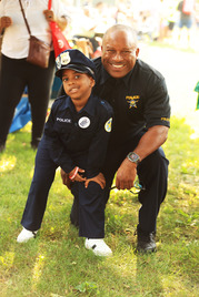 Deputy Chief Roderick Robinson with a kid during the 2025 National Night Out event