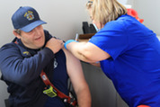 Firefighter/Paramedic Garrett LaFluer getting a flu shot during the 2025 Health & Wellness Fair