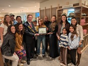 Chief Economic Vitality Officer John Melaniphy presents a plaque to FARE at its grand opening on Nov. 6, 2025.