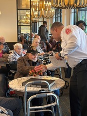 Fire Chief JT Terry greets a veteran during a Veterans Day event at American House in 2025.