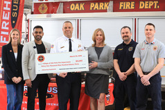 Represntatives from the Firehouse Subs Public Safety Foundation present a check to Oak Park Fire Chief JT Terry