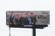 Billboard advertising promoting job openings with the Oak Park Police Department along the I-290 Expressway