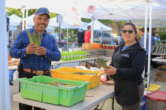 Vendors holding fresh produce at the Oak Park Farmers' Market