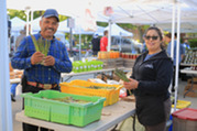 Vendors hold fresh produce at the Oak Park Farmers' Market