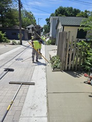 Crews finish pouring concrete as part of an alley improvement construction project.