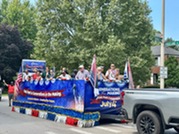 Fourth of July parade grand marshal Emery Lehman aboard a float filled with Village staff and elected officials
