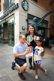 Lieutenant Bob Toth and Firefighter/Paramedic Savannah Reinhart meet with a young community member outside Starbucks.