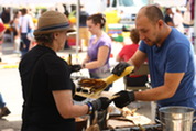 A patron purchases an ear of corn at the Oak Park Farmers' Market Corn Roast
