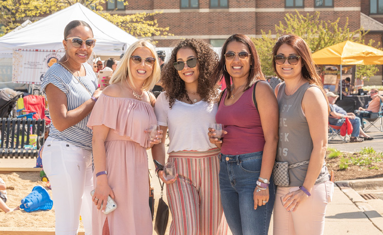 group of five women enjoying wine on a spring day