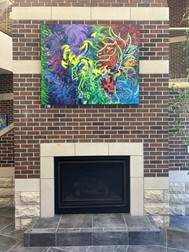 Colorful painting above a fireplace