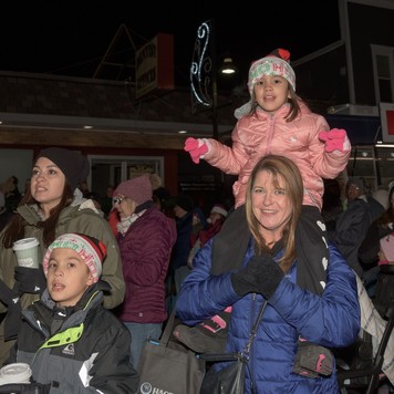 kid on shoulders christmas walk