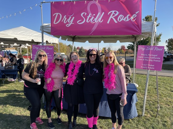 Women survivors with pink boas rose tent