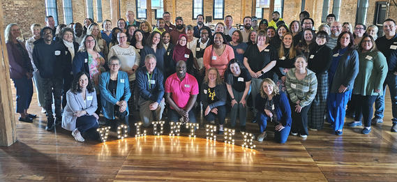 Attendees of the National Volunteer Month special luncheon pose with guest speaker Jacob Jenkins of Serve Illlinois.