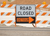 road detour sign with street work.