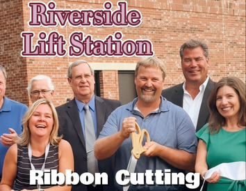 Ribbon cutting of lift station in background with foreground full of people standing behind the ribbon.