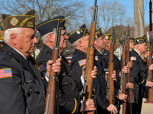 Veterans Day Ceremony of vets holding guns and standing at attention.