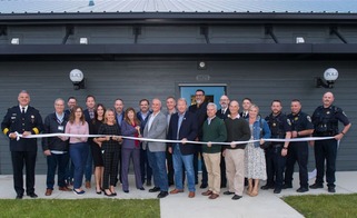 Group shot of police officers, elected and city officials and donors cutting a ribbon at the new Public Safety Training Center.