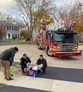 firefighters give candy to kids on Halloween.