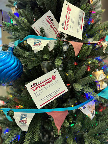 A Christmas Tree with ornaments, foxes, tags and blue balls with lights.