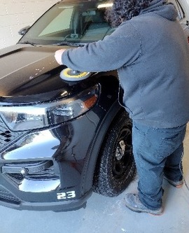 A person uses tools to work on a car.