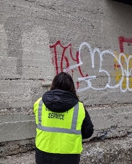 Woman faces wall with grafiti