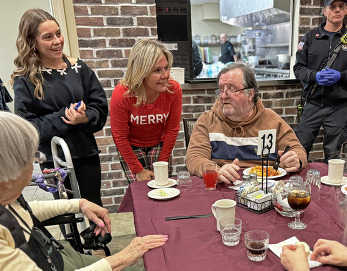 The mayor and her daughter speak with residents during a pasta dinner being served by the fire department.