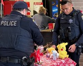 cops wrap presents on a table with a snowflake cloth.