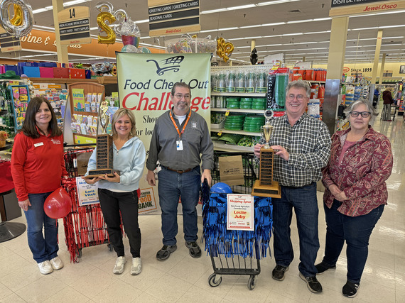 Shopping challenge participants post with groceries, trophies and checks.