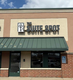 The outside of a building with the sign "Suite Spot" above the awning.