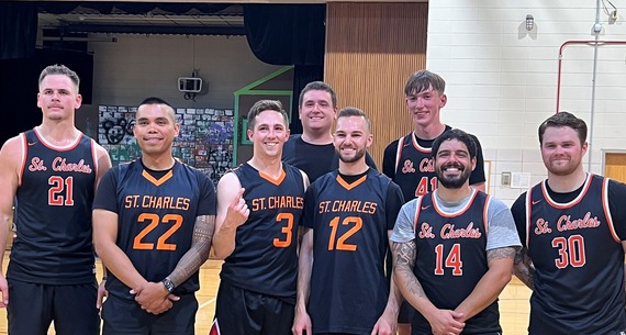 A group shot of police officers dressed in basketball attire after a game.