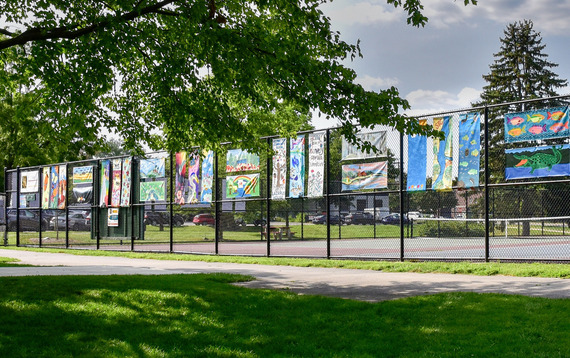 A row of painted banners lines a fence at Mt. St. Mary Park