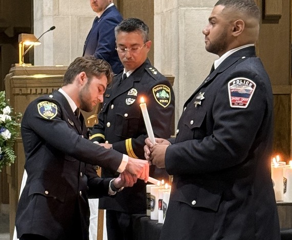 Officer Luke Hohman lights a candle during the ceremony.