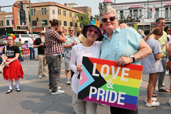 Two women hold up a Pride flag during Pride Fest at the Municipal Building.