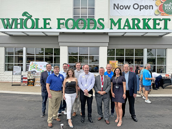 The Mayor, City Council and City staff post for a photo in front of the new Whole Foods Market.