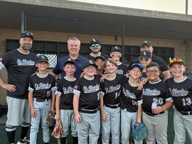 A group shot of baseball players as the sun sets behind the dugout. 