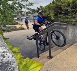 A police officer rides his bike up a flight of stairs.