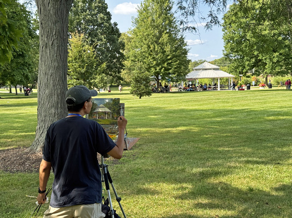 A man paints on an easel an outdoor scene at Mt. Saint Mary Park.