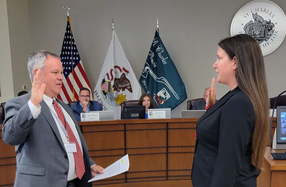The Mayor swears in the new city clerk in council chambers.