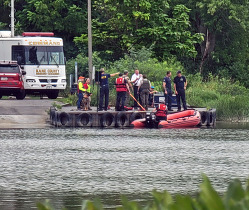 A team of firefighters and members of the water rescue team huddle on the dock of Boy Scout Island.