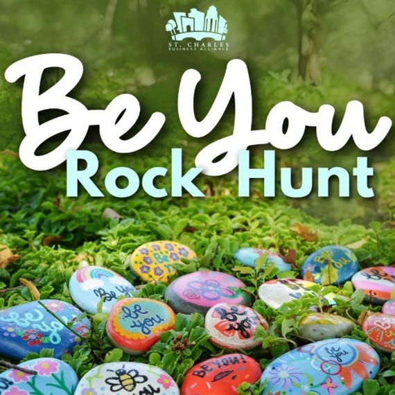 dozens of painted rocks sprawled out in the grass.